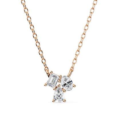 A necklace featuring emerald, oval, and pear-shaped diamonds set in rose gold.