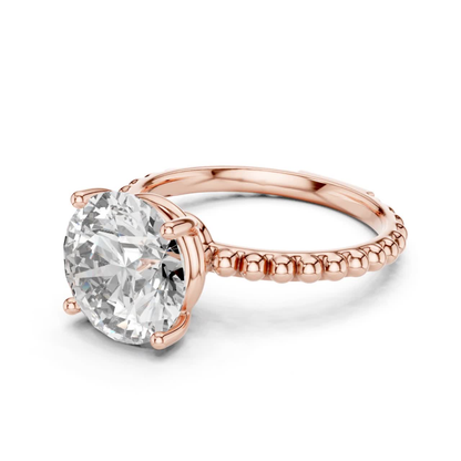 Rose gold round solitaire diamond front side view
Round cut diamond ring with beaded rose band
Four prong round diamond solitaire rose gold ring
Rose gold beaded band solitaire engagement ring
Angled view of round diamond rose gold ring
Rose gold ring with raised round diamond
Round brilliant diamond beaded shank ring
Rose gold solitaire ring with polished beaded band
Front side angle round diamond engagement ring
Rose gold round diamond prong setting ring