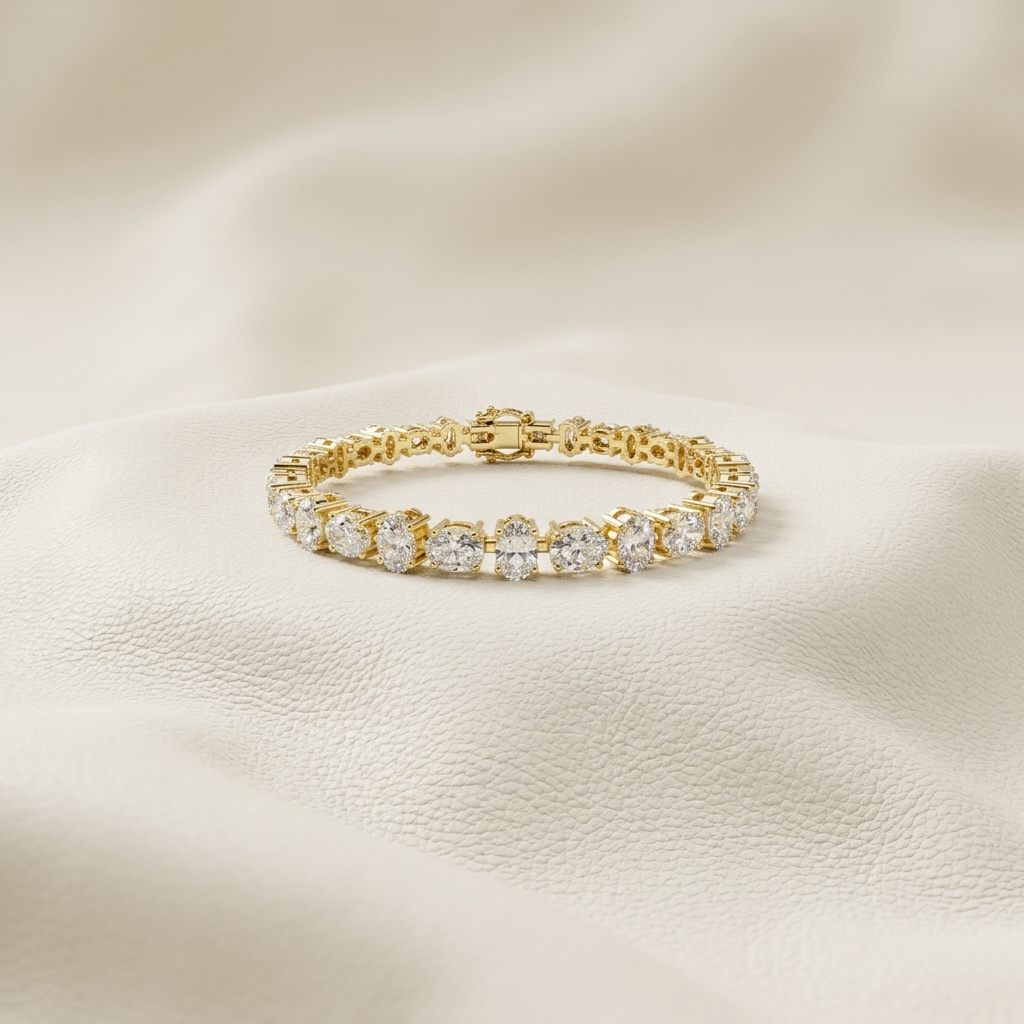 Oval lab grown diamond tennis bracelet in yellow gold with elegant four-prong settings.

